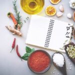 Rezeptbuch mit verschiedenen Gewürzen und Gemüsen