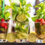 Drei Gläser mit Rum, Früchten und Minze
