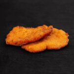 zwei Schnitzel auf schwarzer Oberfläche