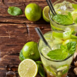 Zwei Caipirinhas geschmückt mit Limetten auf einem Tisch