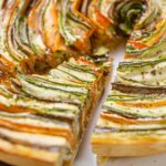 Ratatouille auf dem Teller. Ein Stück wir mit einem Tortenheber entnommen.