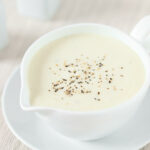 Bechamelsauce in einem Becher mit Untertasse