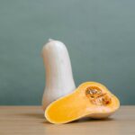 Butternusskürbis geteilt in der Hälfte mit grünem Hintergrund