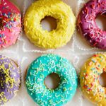 Sechs Donuts in unterschiedlichen Farben mit Streuseln